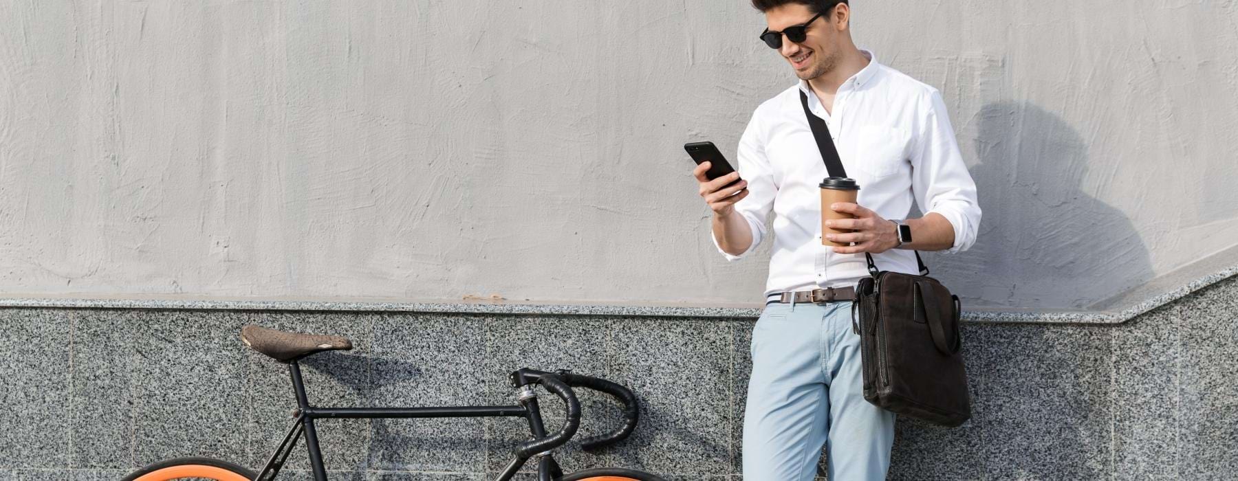 a man holding a phone and a bicycle